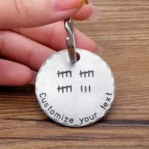 Cirkelvormige sleutelhanger met turfstreepjes en tekst