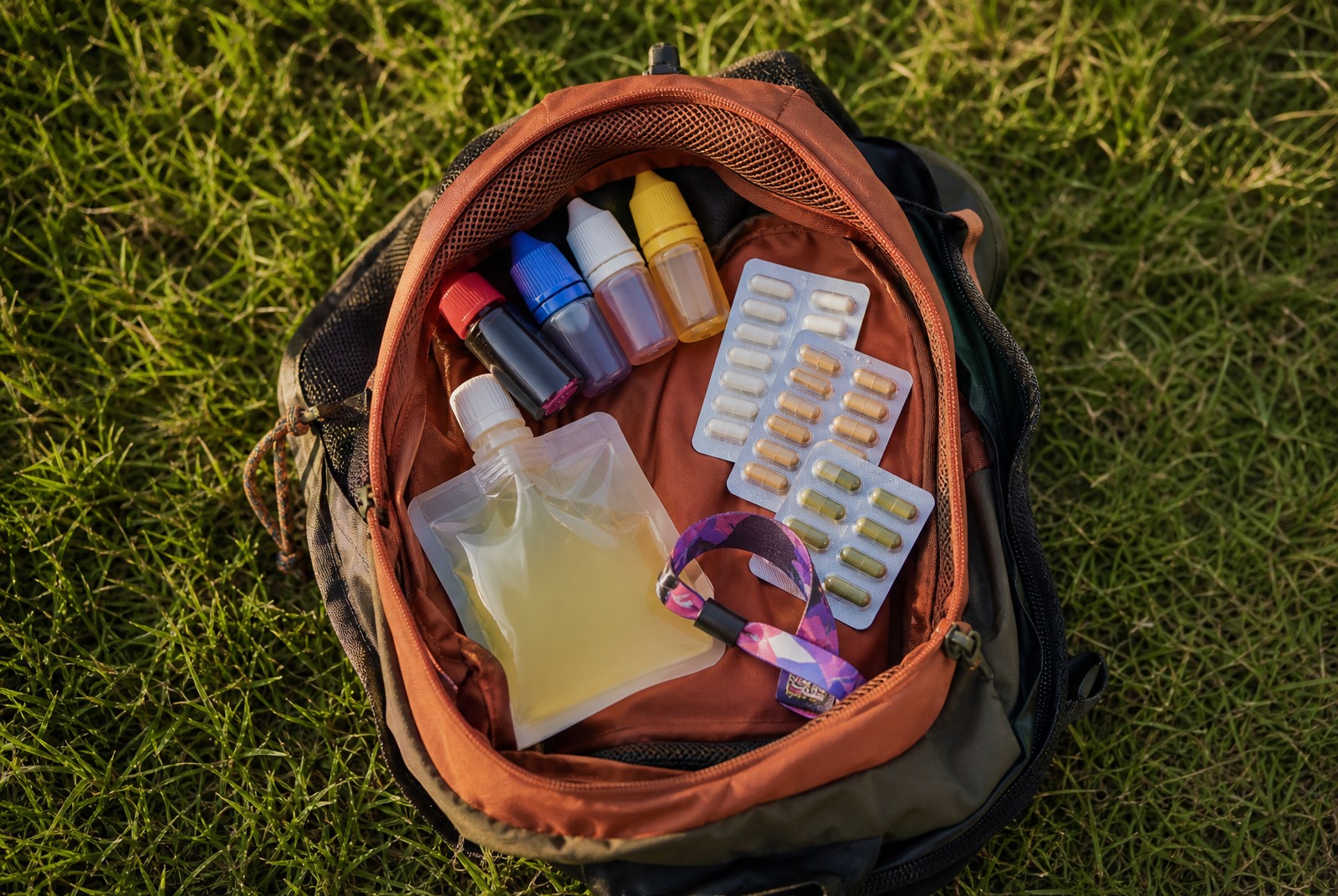 Festivalchecklist met smartshopproducten in een rugzak op festivalterrein