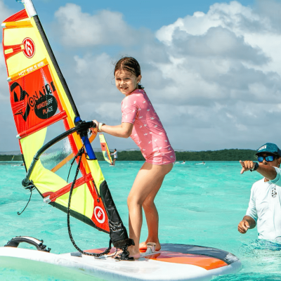 meisje op windsurfplank tijdens een windsurfles voor beginners op Sorobon Bonaire