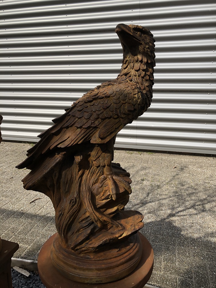 Detaillierte Skulptur eines Adlers, der auf einem Felsen sitzt, aus oxidiertem Stein