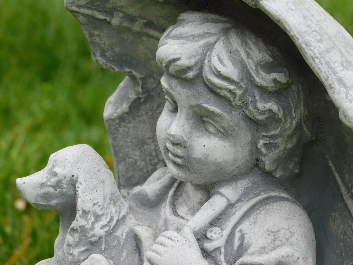 Schattig tuinbeeld van een kind met hond, stenen beeld met tafereel