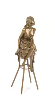 Een bronzen beeld van een topless dame op barkruk