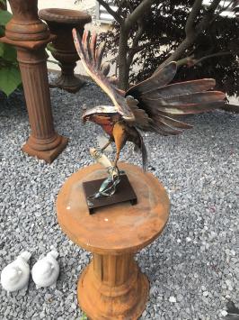 Een metalen kunstwerk van een adelaar die een vis vangt, 'IRON EAGLE'