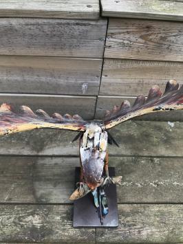 Een metalen kunstwerk van een adelaar die een vis vangt, 'IRON EAGLE'