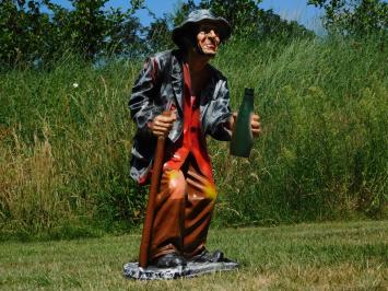 Groot beeld van een oude man met wandelstok en drankfles
