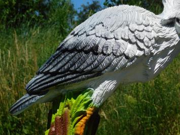 Grote reiger met vis van polystone als natuurgetrouw beeld