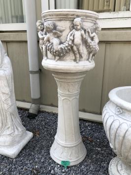 Prachtige zware bloempot-vaas uit vol steen met engelen op sokkel.