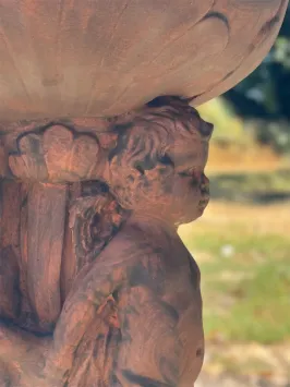 Klassieke stenen bloembak met engelfiguren in oxidekleur