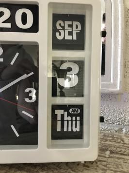 Een klok met jaar, datum en tijd, met standaard, maar kan ook aan de muur hangen, wit