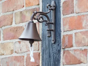 Klassische Türklingel aus Gusseisen mit Wandhalterung und Zugschnur