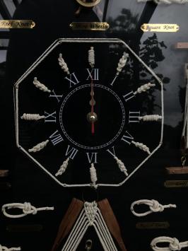 Eine schöne Ausstellung von maritimen Knoten in einer Vitrine, mit einer Uhr darin!