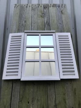 Een spiegel met openslaande deuren, gemaakt van hout