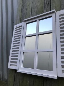 Een spiegel met openslaande deuren, gemaakt van hout
