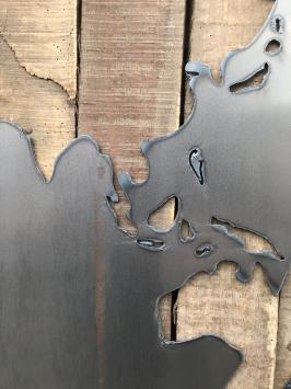 Großes Wandornament aus Holz mit einer Welt darauf, ein Meer aus Metall